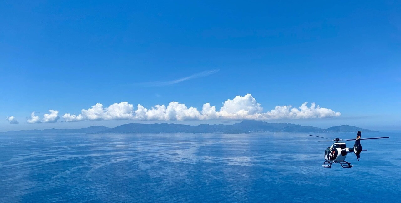 hélicoptère survolant les îles des Seychelles et l’océan turquoise