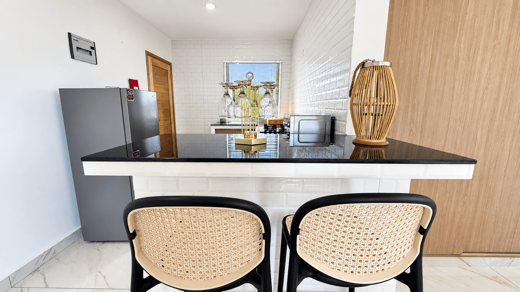 Kitchen island with a stone worktop and woven bar stools