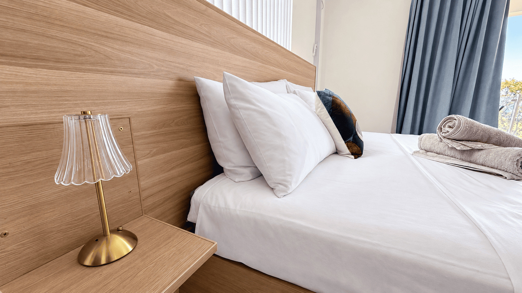 Bed with a wooden headboard in a Creole Cottage apartment
