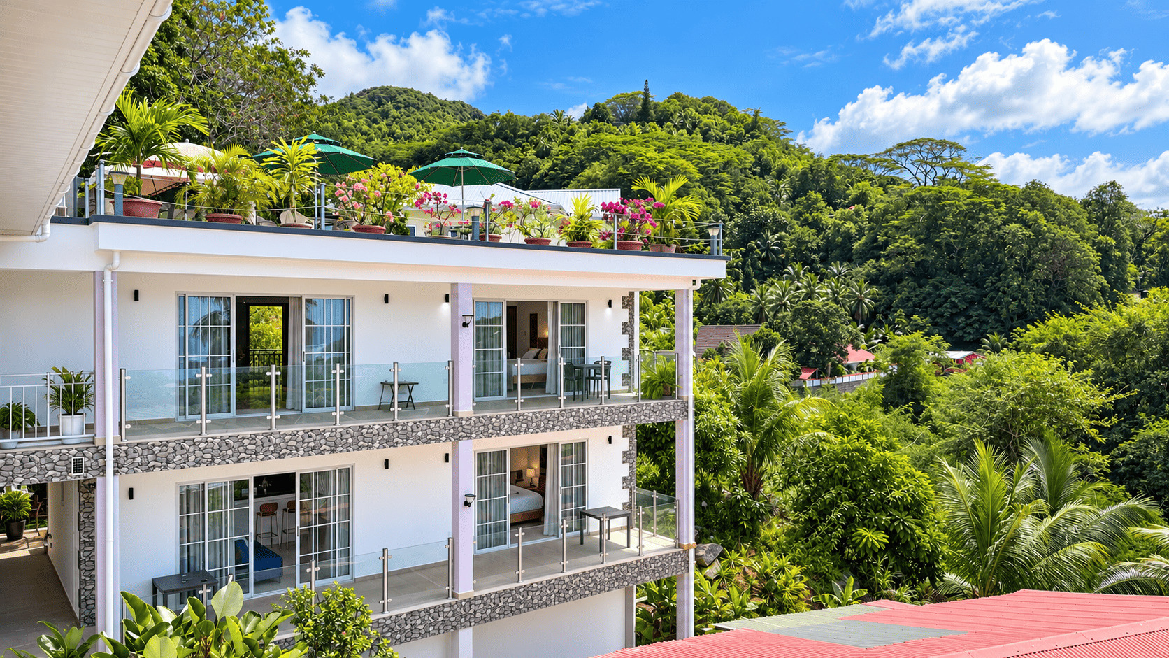 Facade of Creole Cottage Apartment with balconies surrounded by tropical greenery